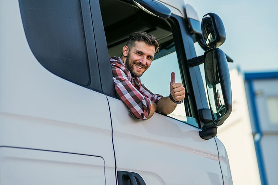 happy trucker in his truck with tax issues resolved