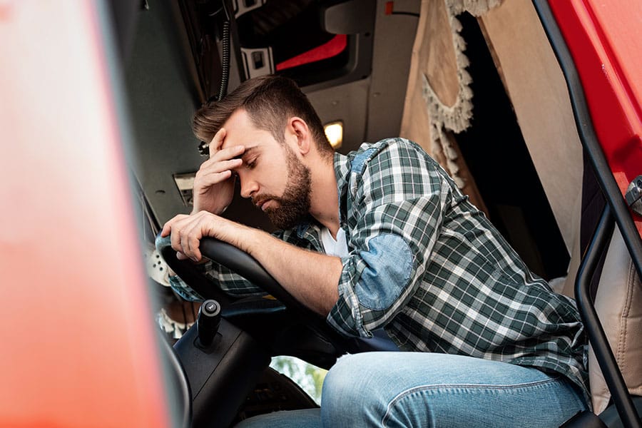 trucker sitting in the truck sad because of tax problems